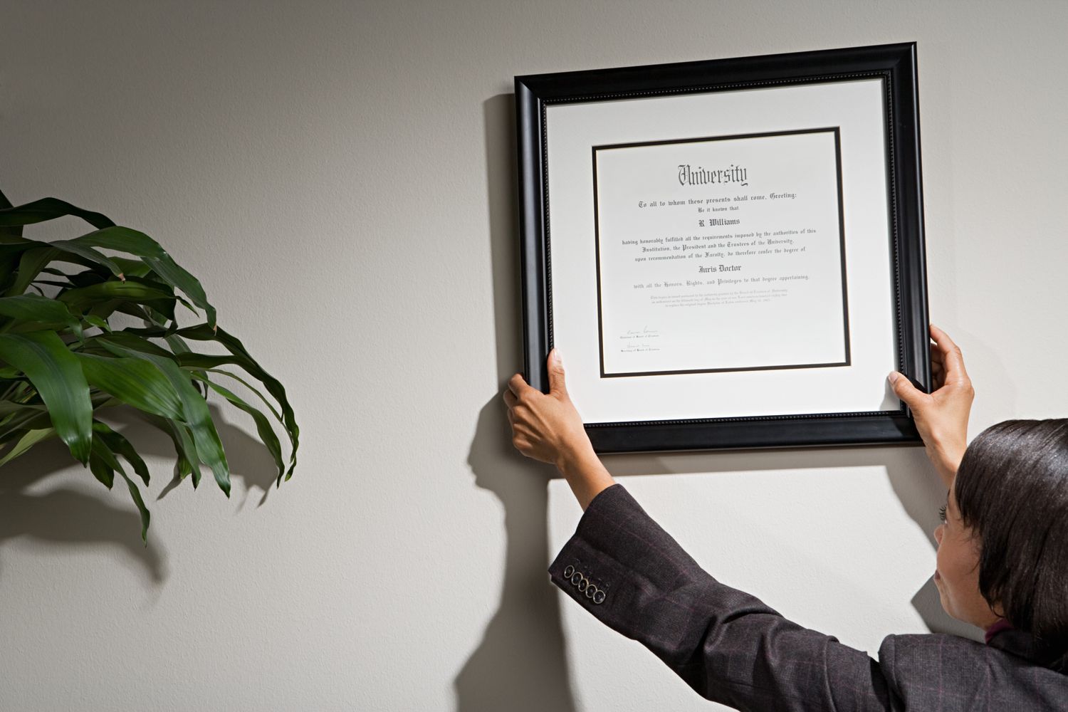 Financial advisor hanging credentials on the wall.
