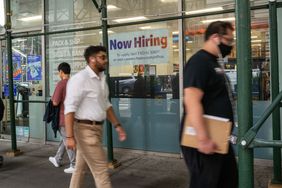 A "now hiring" sign is displayed in a window in Manhattan on July 28, 2022 in New York City