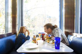 Father and daughter eating lunch in a diner.