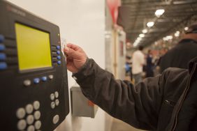 Worker scanning time clock with his id card