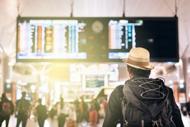 A backpacking flyer steps into the crowded terminal confident the perks provided by his airline credit card will see him comfortably to his destination.