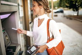 A bank customer uses an ATM machine