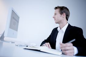 Young Businessman Looking at Business Plan on his Computer