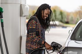Woman at a gas station refueling her car.