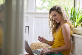 Smiling woman inputting credit card info on a laptop