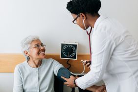 A doctor checks a patient's blood pressure.