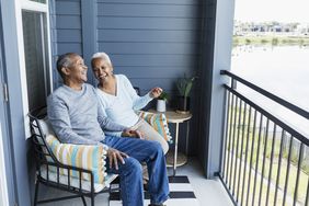 Laughing senior couple on porch overlooking a lake