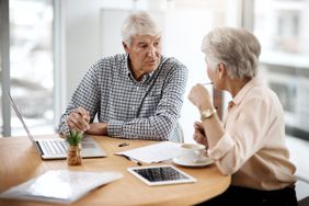 elderly couple talking about financial matters in front of a computer