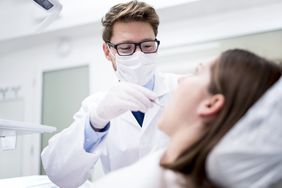 A dentist works on a patient