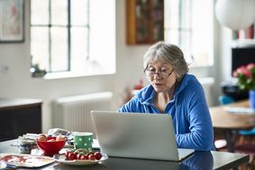 A person looks at an open laptop.