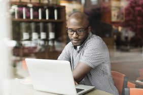 Man using laptop in coffee shop