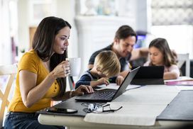 Mother working from home while children attend school online