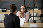 Confident millennial female applicant talking at job interview answering questions