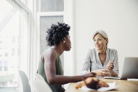 Two friends discuss finances and how to build credit at a table