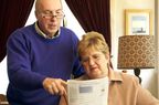 an older couple looking at documents to determine mandatory spending