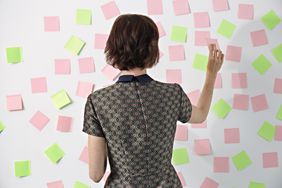 Woman placing sticky notes on board