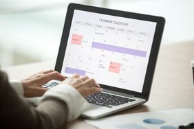 Person updating calendar on laptop.