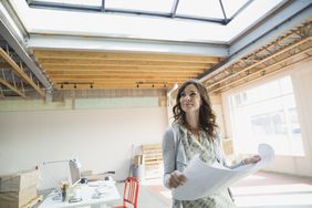 Businesswoman holding blueprints in new office