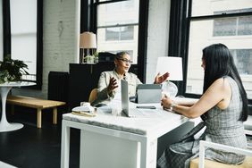  two women talking to each other across a desk about financial matters