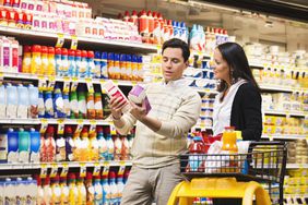 Man and woman comparing two brands of a product in the grocery store