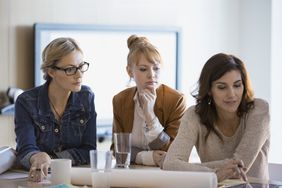 Business women looking at plans in a meeting