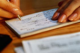 Person writing a check in a checkbook