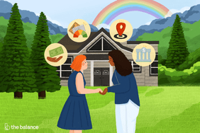two women standing in front of a house holding hands