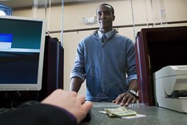 A man deposits cash with a bank teller. 