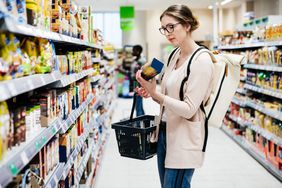 A person looks at a product in a grocery store.