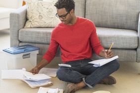 Man working on taxes on his living room floor