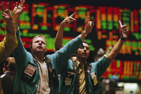 Stock traders waving arms on floor of stock exchange