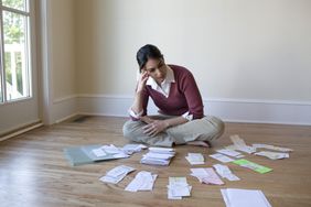 Woman with bills laid out in piles on the floor