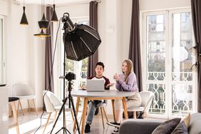 Video bloggers making a YouTube video with a professional camera on a tripod at home.