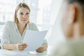 A woman reviews a resume during a job interview. 