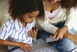 Mother and her daughter using a laptop for home shopping