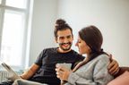 man and woman sitting on couch discussing finances