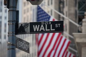 A sign for Wall Street and American flags in New York, U.S.