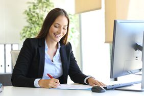 Woman signing business letter in office