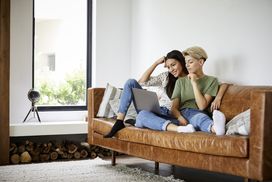 A couple sitting on a couch watching a movie