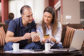 Latin descent couple paying monthly bills at home.