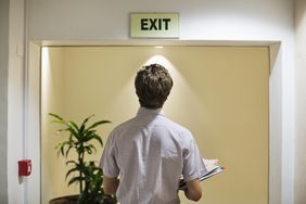 Businessman examining exit sign in office