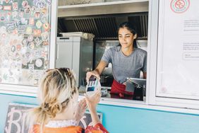 Food truck owner presenting credit card reader to customer