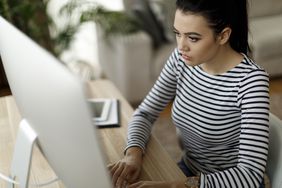 Person looking at computer monitor wearing striped shirt