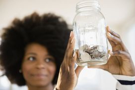 Woman holds jar of coins