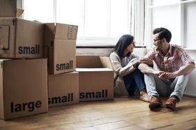 Couple surrounded by boxes while moving into new home