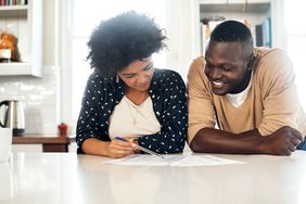 Couple reviewing papers together at their kitchen table