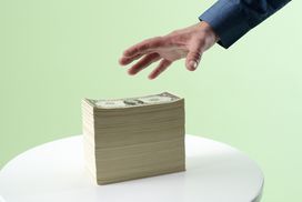 Hand reaching for stack of cash