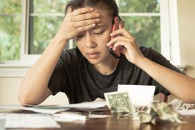 Stressed woman with no money looking at her credit card bills and monthly payments.