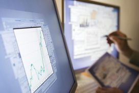 Man examining graphs and charts on computer screen