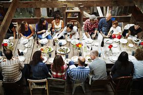 A group of people gather at their communal living area's dining table to share a meal